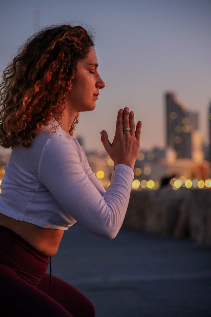 young woman meditating hands in prayer