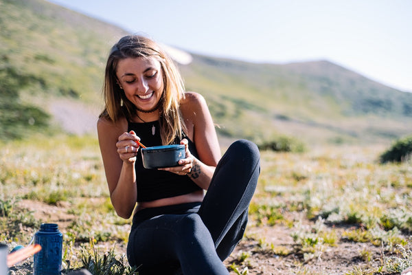 jeune femme qui mange son repas en plein air