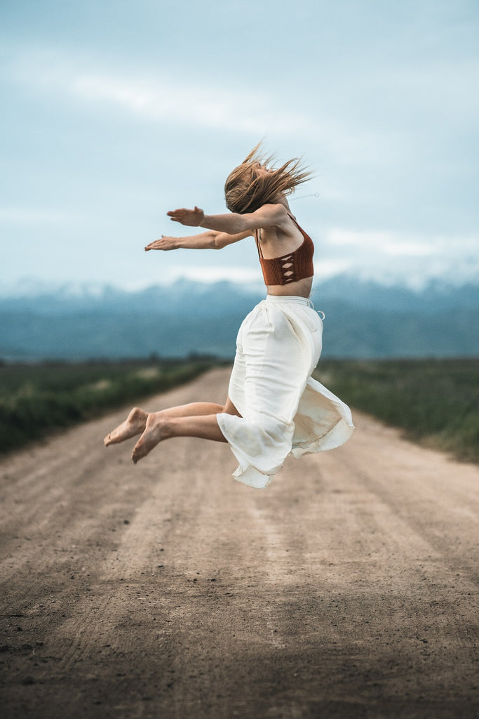 young girl jumping for joy, hair in the wind