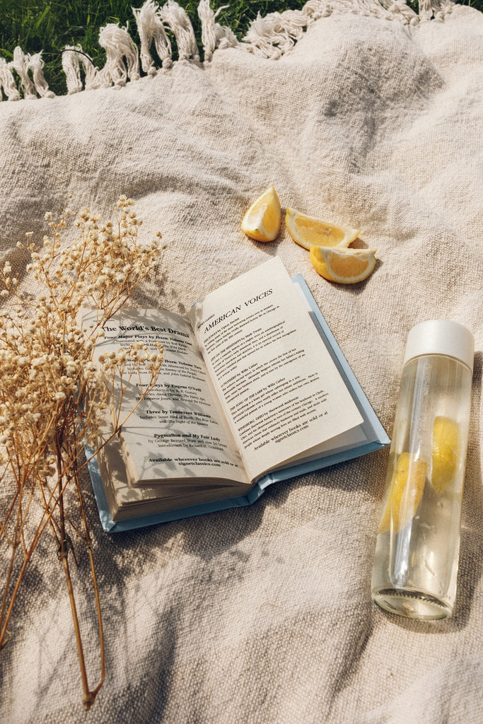 open book on a white cover with a water bottle