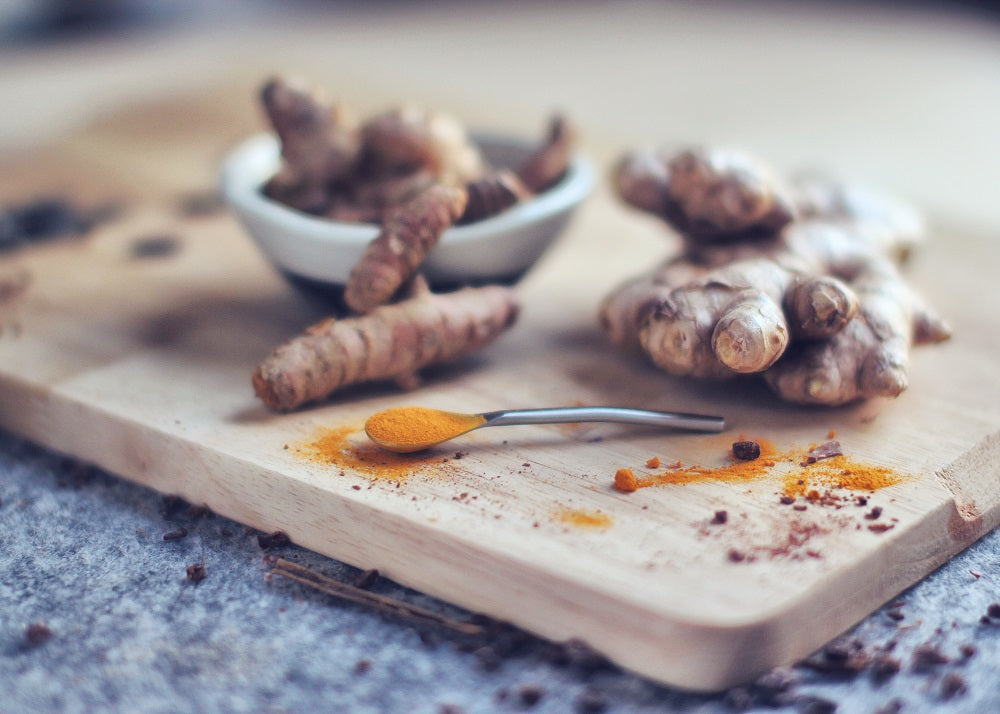 racines de curcuma sur une planche en bois