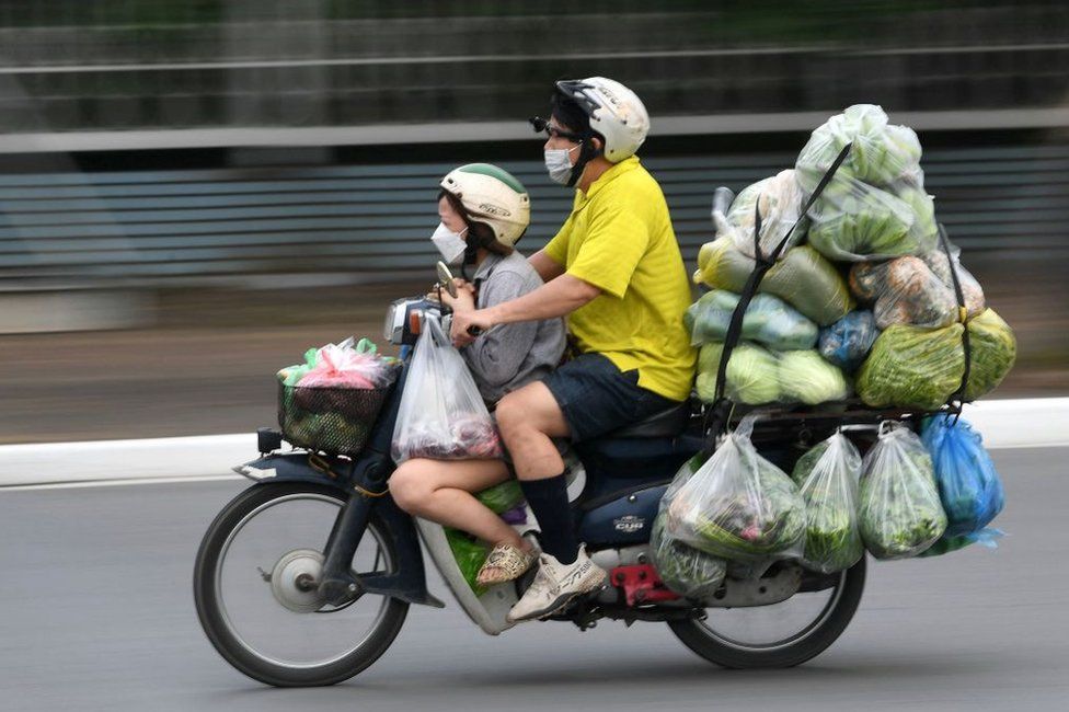 It is not unusual to see heavily laden motorbikes across Asia, such as this example of a man and child in Vietnam