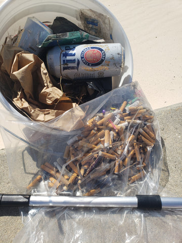 a bucket filled with litter cigarette butts beach clean up