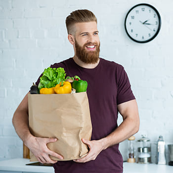 Mann mit Gemüse-Einkauf