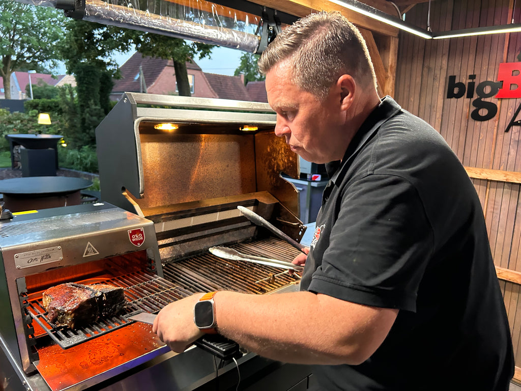 Ein Mann brät Fleisch auf seinem O.F.B.