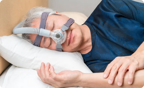 Middle age Asian man wearing CPAP headgear during his sleep 