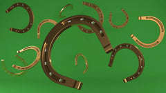Assorted New Horse Shoes on Green Background: A Collection of Freshly Designed Equine Footwear