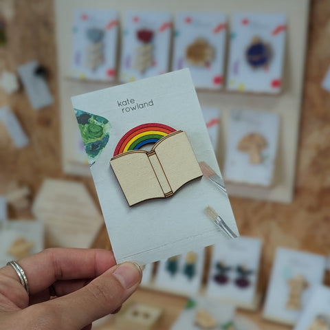 Wooden brooch of a book and rainbow