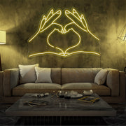 yellow love hands neon sign hanging in living room
