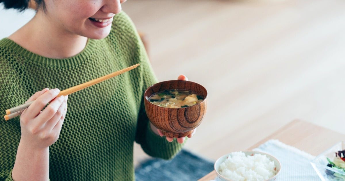 みそ汁を飲む女性