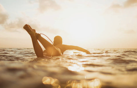 Surfer on funboard during sunset