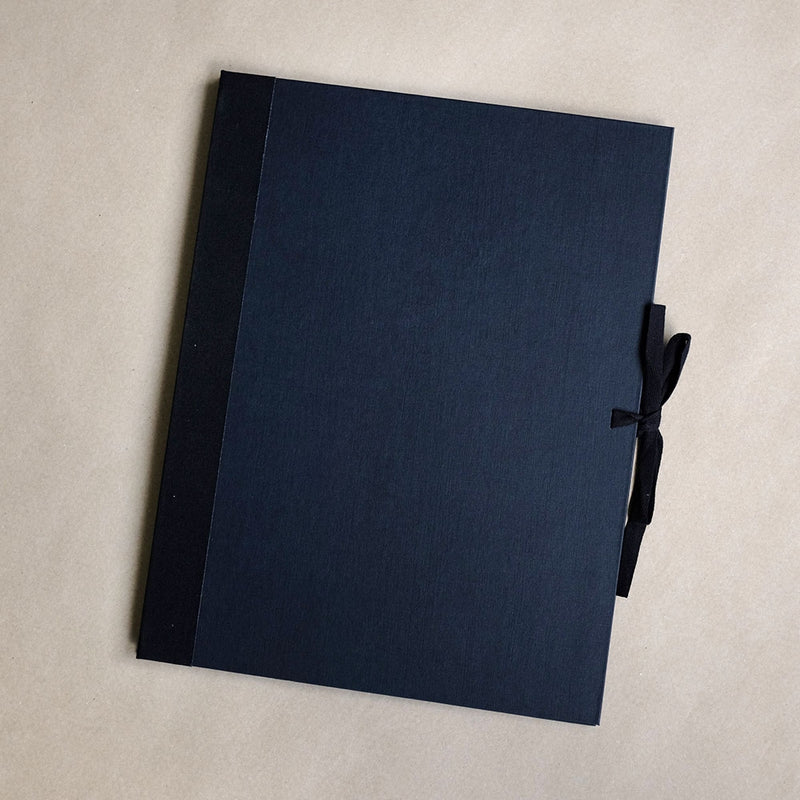 Well styled version of the classic art portfolio, inexpensive and an ideal way of storing and transporting prints, as well as supplying them to clients. They feature tough black texture finish board, with fabric reinforced corners. The portfolios are closed and fastened with strings on each open side.