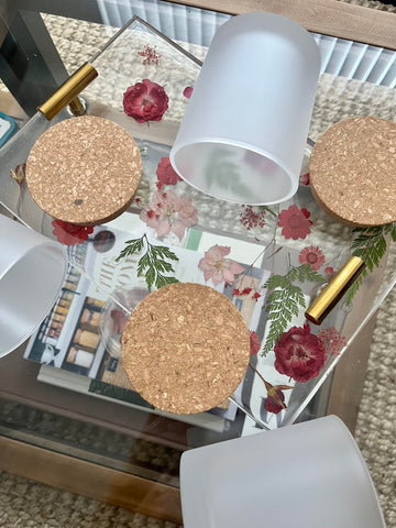 clear matte glass with cork lids on floral decor tray on glass coffee table