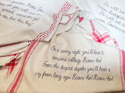 Sångtexter broderade på linnehanddukar för dekor till Astrid Lindgrens Näs, utställning