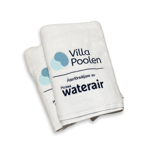 Vita fluffiga frottéhanddukar med broderat motiv för Villa Poolen Stockholm AB. 