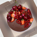 Double Chocolate cake with fresh cherries, redcurrants, strawberries and edible flowers