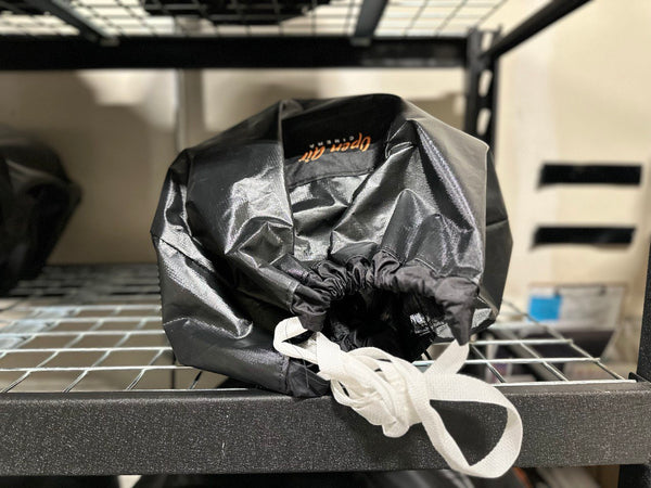 An open Air Cinema storage bag containing the outdoor movie screen well stored on an iron rack indoors