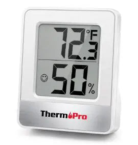 A digital white weather thermometer showing the temperature as 72 fehrenheit and the humidity as 50%