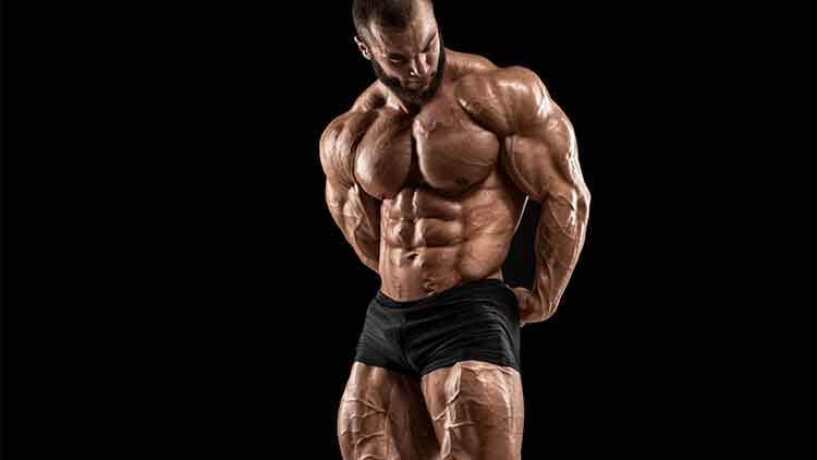 Bodybuilder man isolated on the black background. Strong male naked torso abs