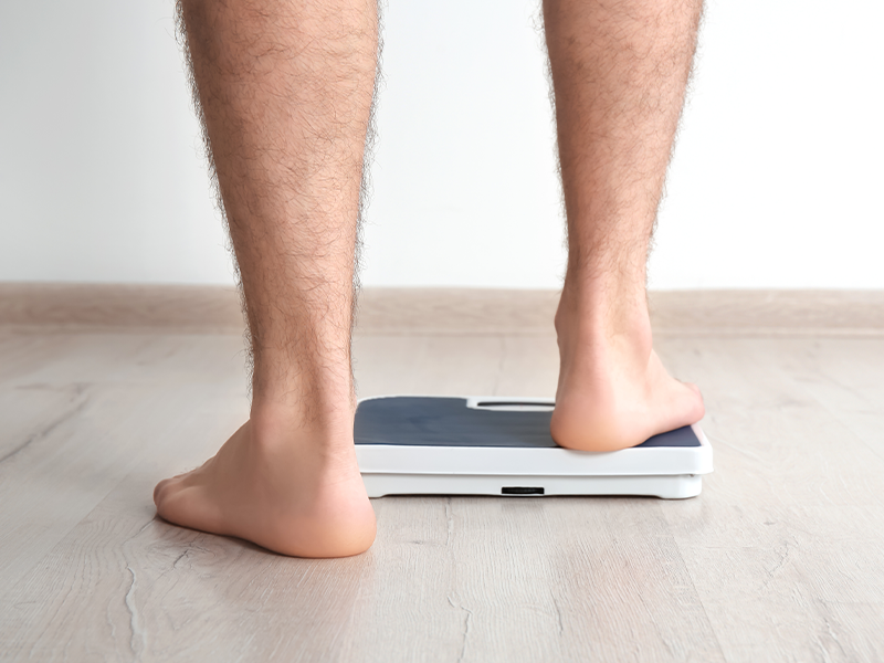 Overweight man standing on scales