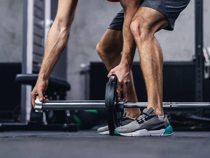 Weightlifter adding weight to barbell