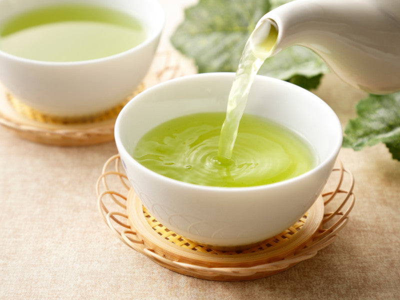 green tea being poured into a cup