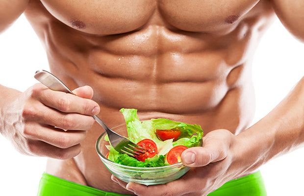 weightlifter with abs eating salad
