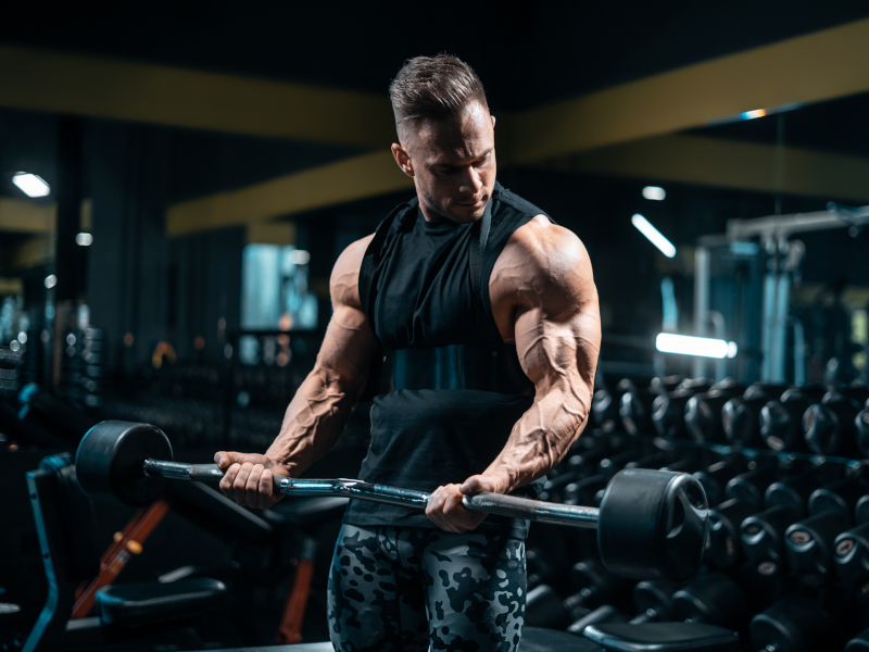 Muscular man doing barbell curls