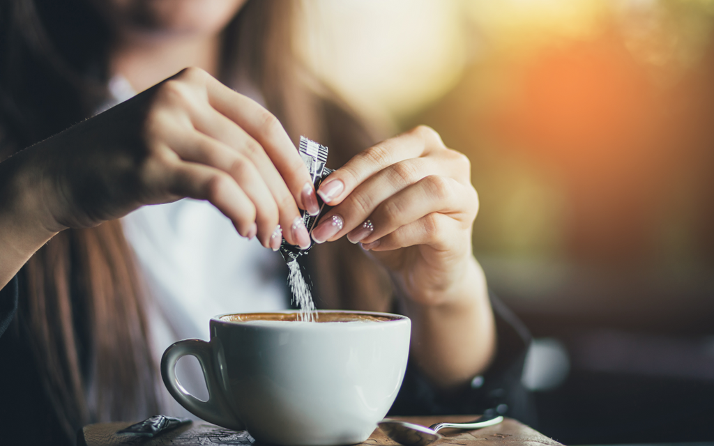 Pouring sugar into coffee