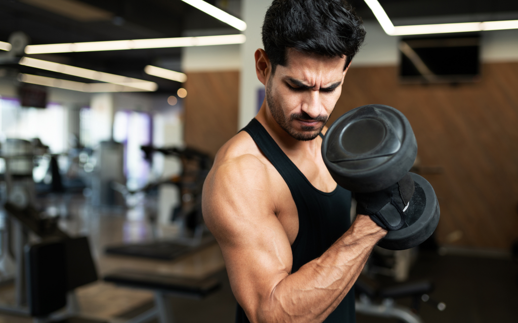 Man doing dumbbel curls for progressive overload