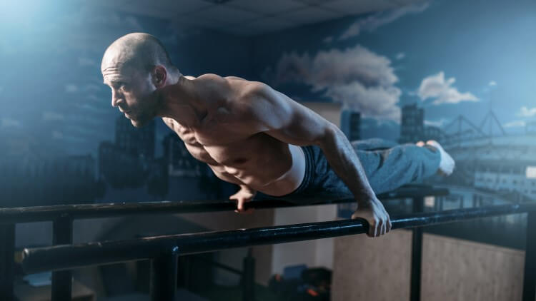 Man balancing horizontally on gymnastic bars