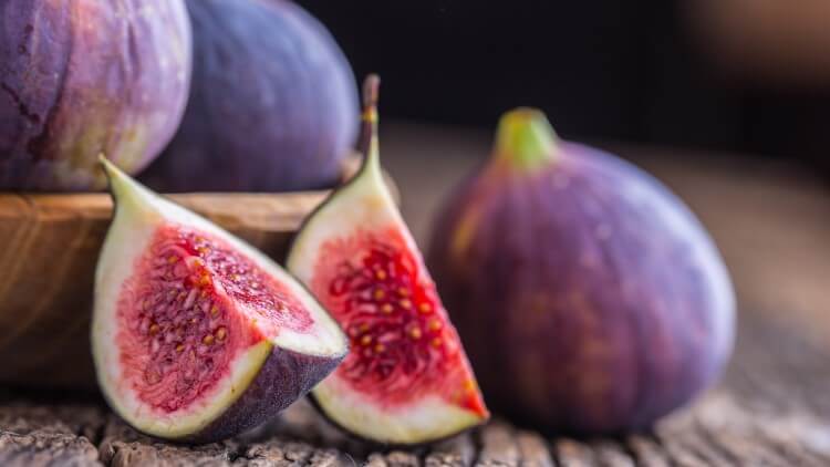 Sliced figs on wooden background