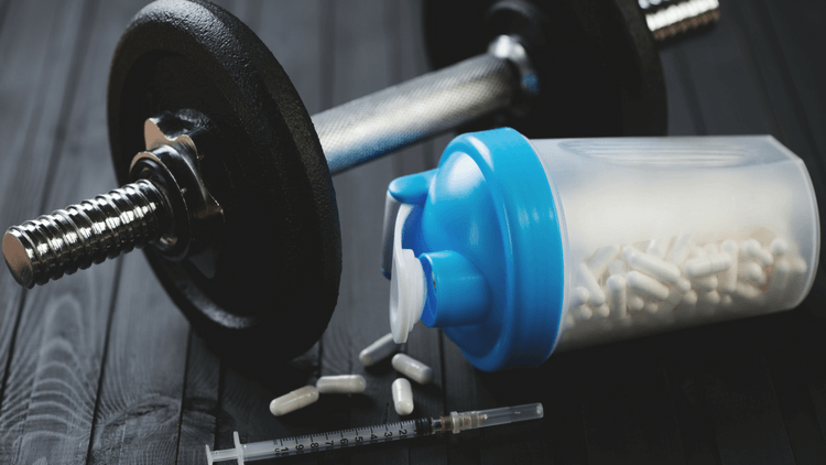 bottle of Dianabol and weights