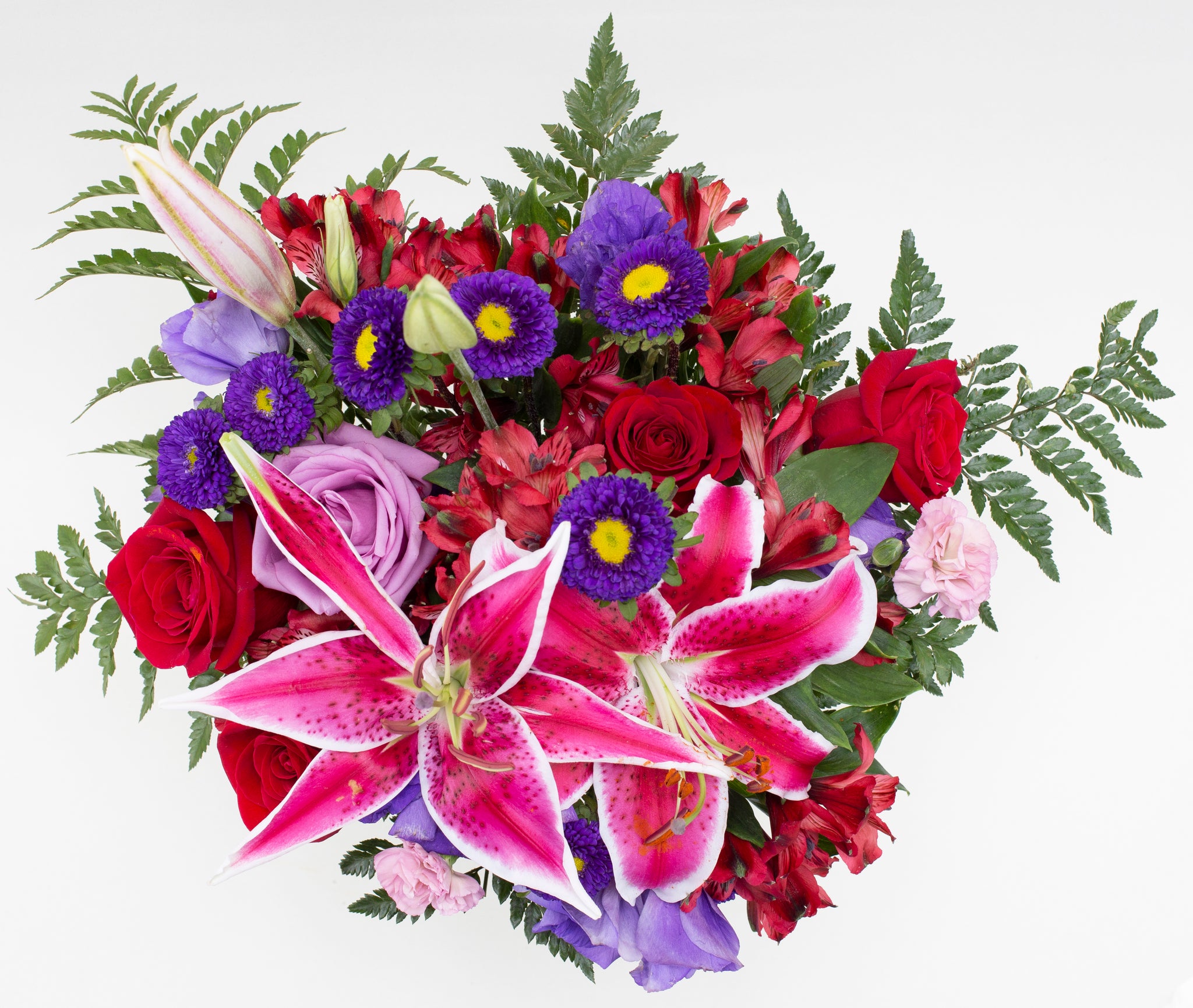 Array of Blooms Top -red roses , lavender carnations , red lilies , purple lisianthus , purple matsumoto asters , greens , vase arrangement