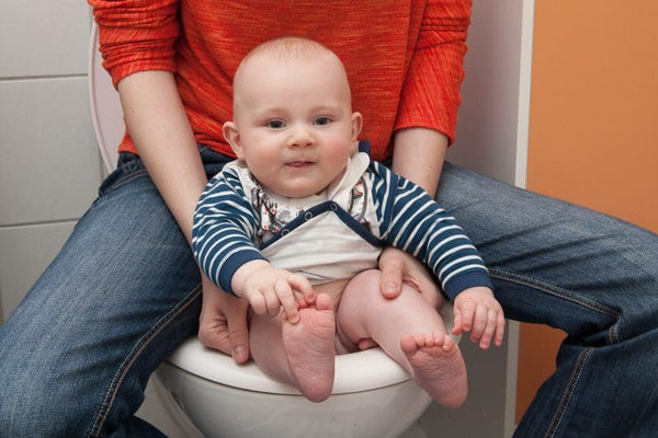 Baby abhalten auf der Toilette sitzen