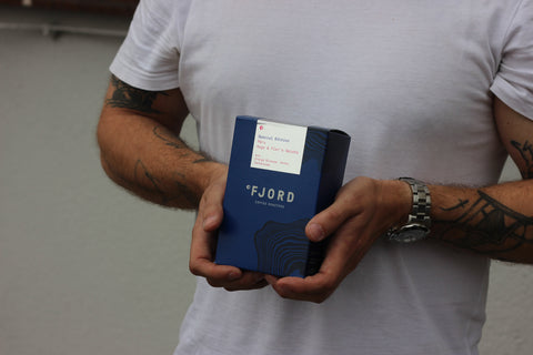 A member of the Fjord team holds a box of roasted Geisha coffee.