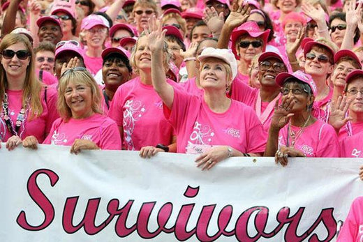 Image of many ladies in pink holding a sign that says "Survivors"