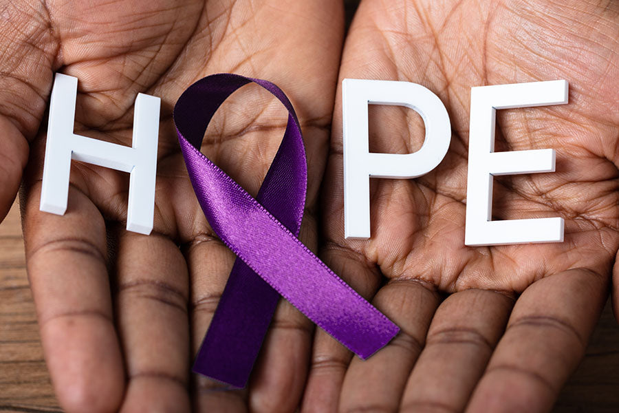 Hands holding a purple ribbon with the word "Hope"