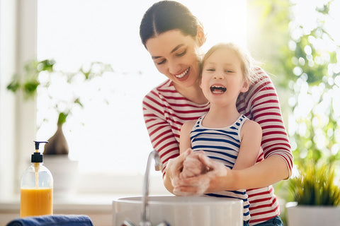 Mother and daughter washing hands together - our new normal