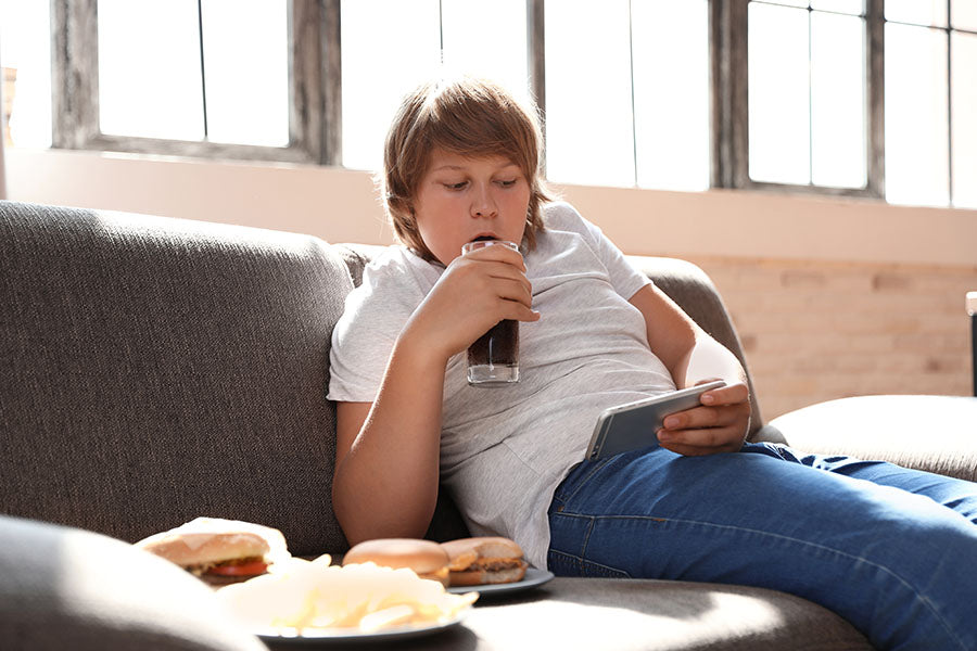 Image of boy on couch stuffing his face