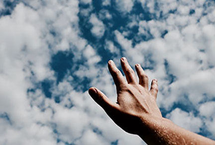 Image of a hand reaching to the sky asking for assistance