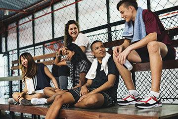 image of teens relaxing in the bleachers after game