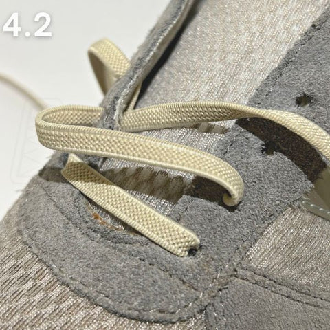 Detailopname van een straight-bar rijgpatroon in een grijze schoen, een veelgezochte techniek voor veters in schoenen doen