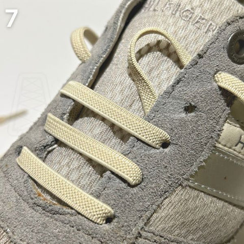 Close-up van de straight-bar rijgmethode op een grijze schoen, een ideale manier om veters snel en stijlvol in schoenen te doen