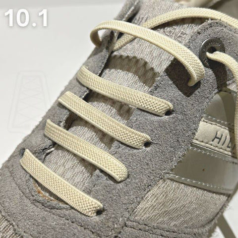 Visuele handleiding van beige veters rijgen in een grijze schoen met een straight-bar patroon voor een strakke uitstraling