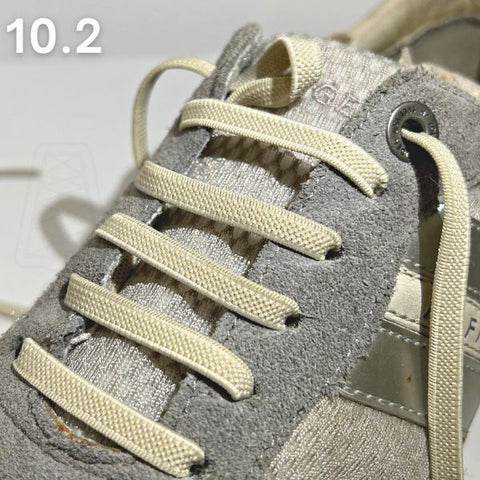 Stap-voor-stap demonstratie van veters in schoenen doen met een straight-bar methode op een grijze schoen