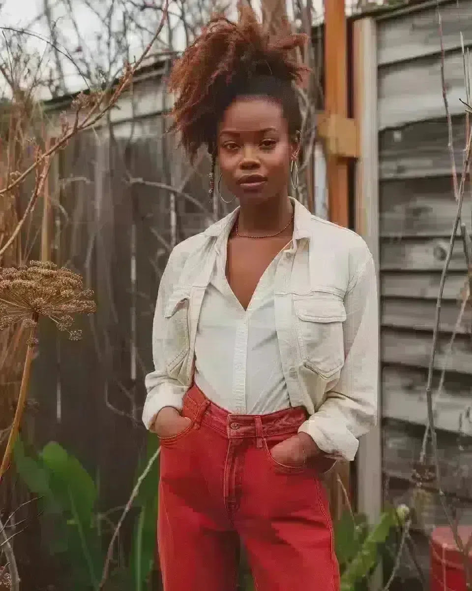 Full-length photo of a person in indigo denim, outdoor country-specific backdrop. White shirt and red color denim.