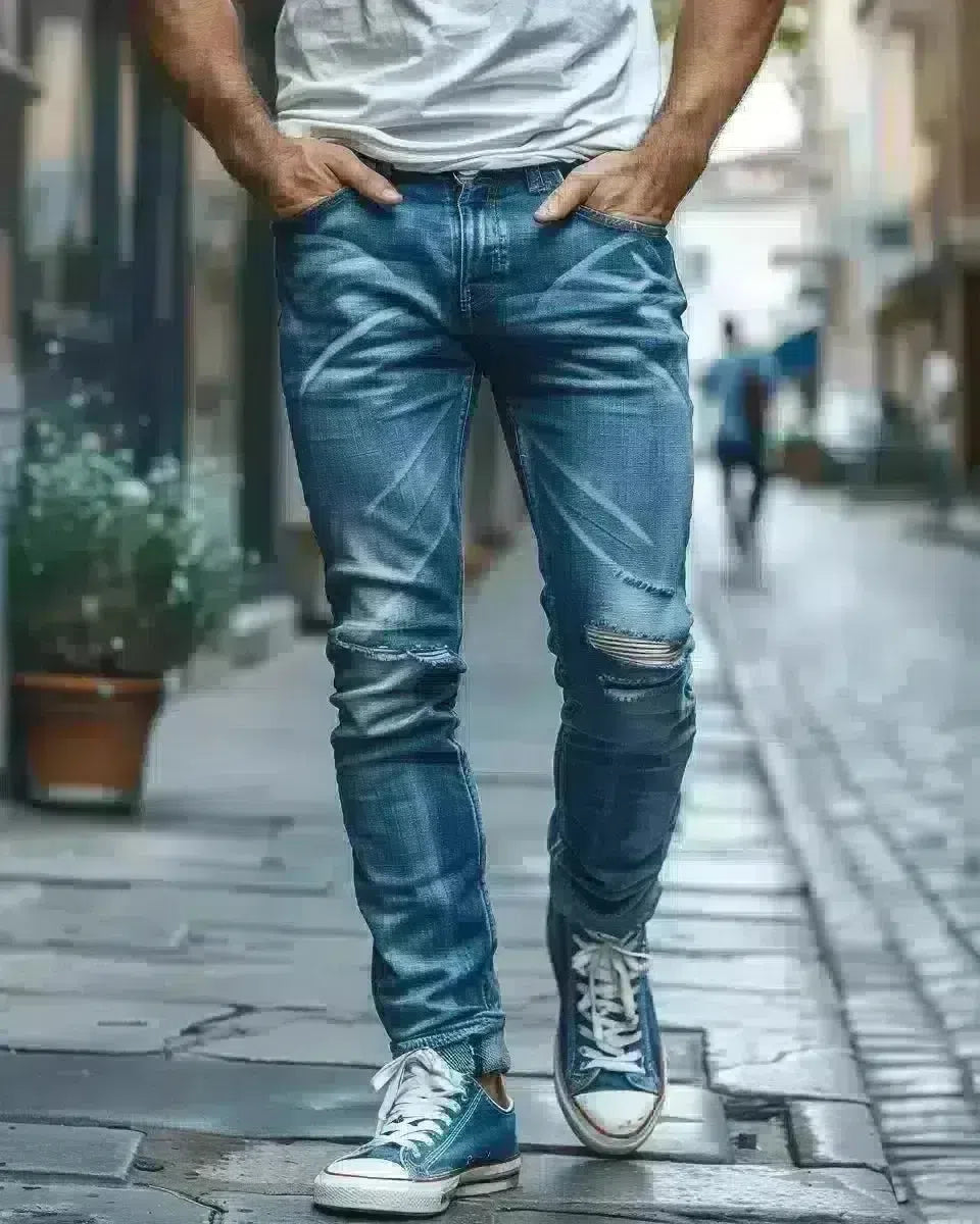 Confident man in blue ripped jeans, urban outdoor setting, denim detail. Spring season.