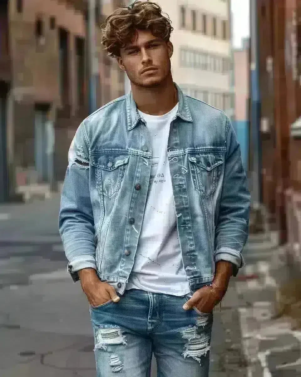 Male model in faded blue ripped jeans, urban outdoor setting, clear denim details. Spring season.