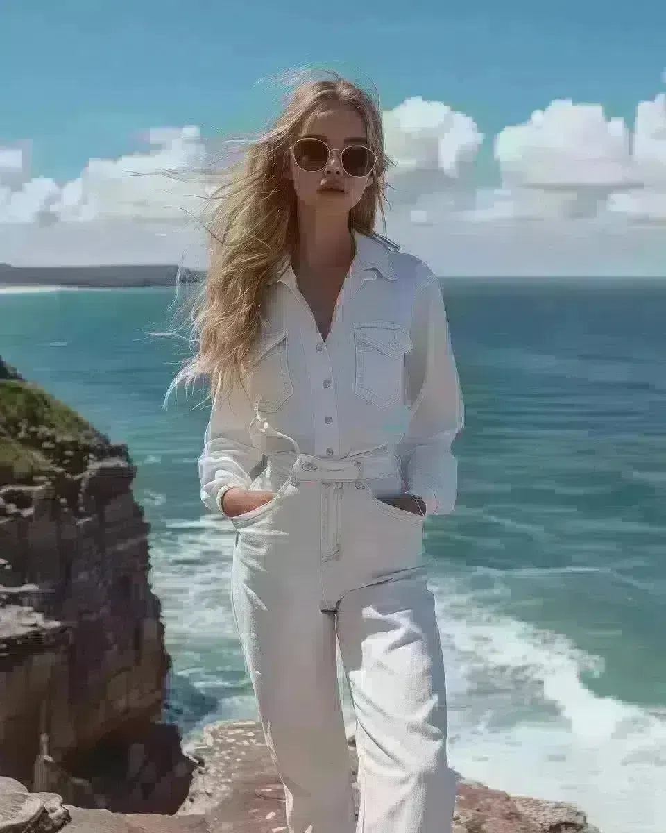 Female model in white denim jumpsuit against Queensland coast backdrop. Winter  season.